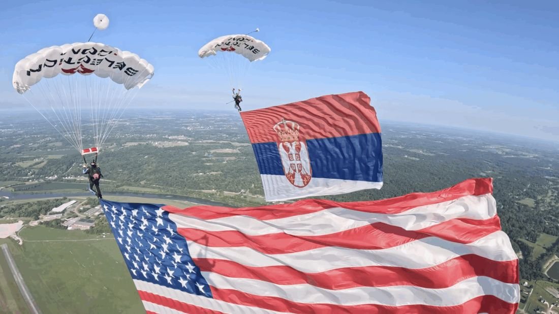 Close view of the American and Serbian flags in flight